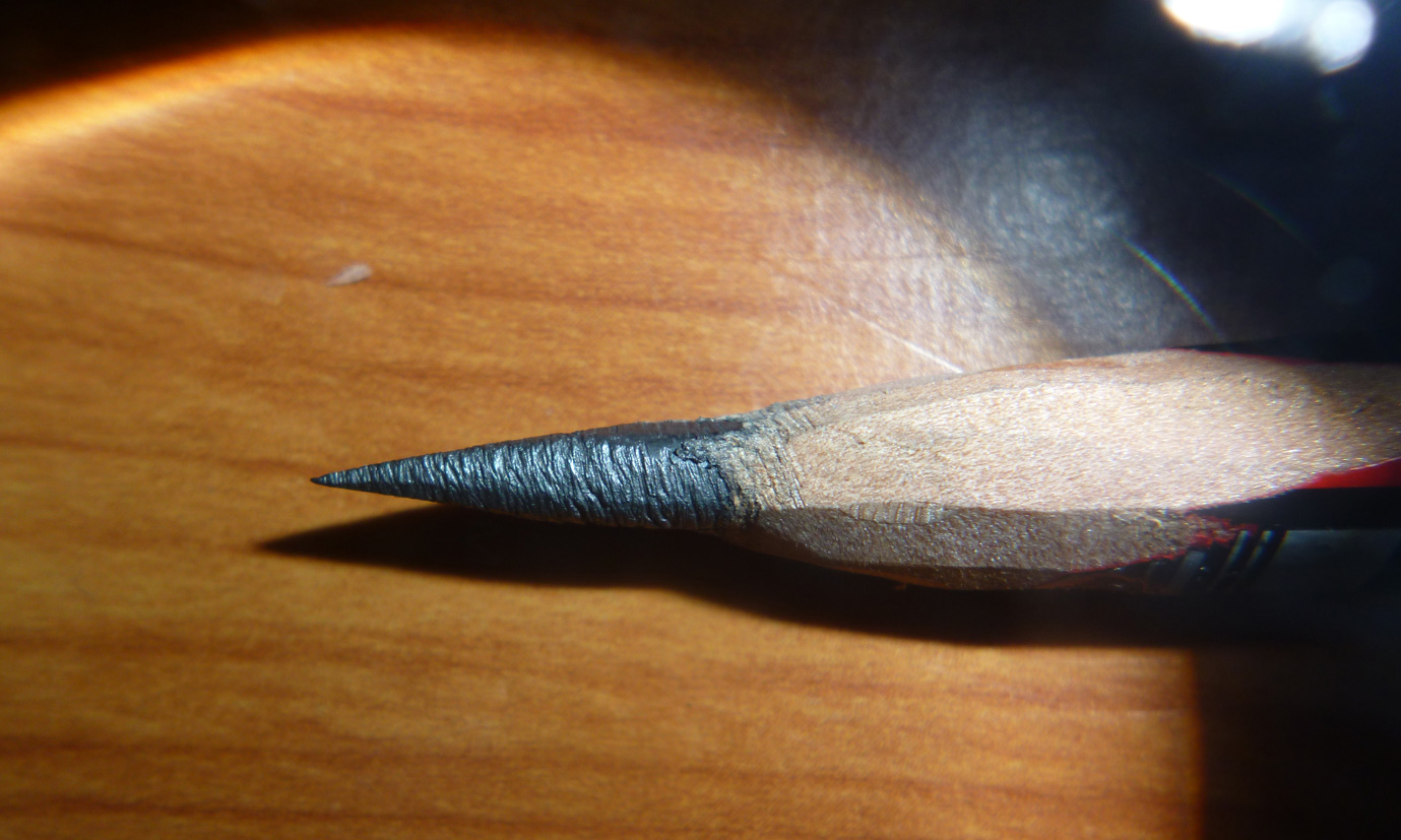 A very sharp lead pencil under a magnifying glass